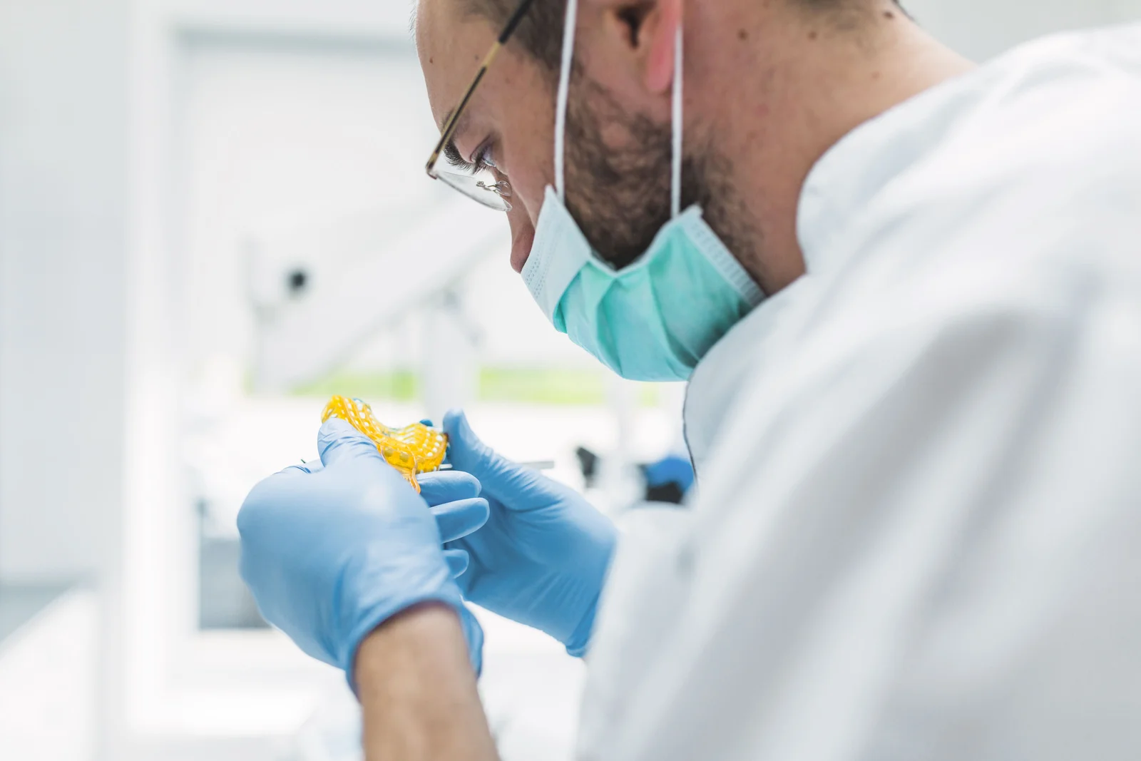 Tandtechnicus van Het-Best controleert een werkstuk in het laboratorium